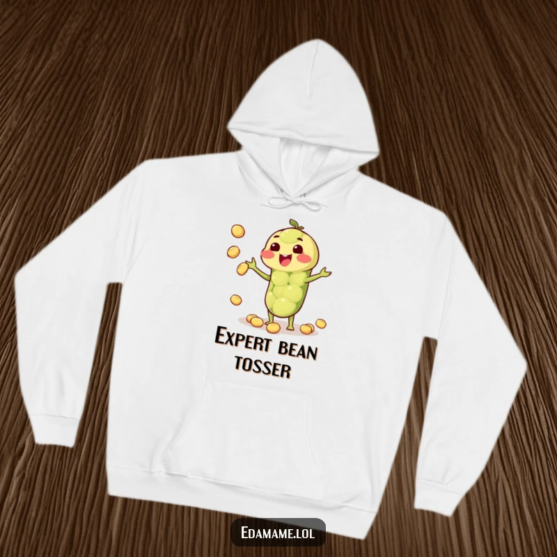 Funny hoodie depicting a joyful anthropomorphic edamame pod juggling small beans, offering both comfort and amusement.